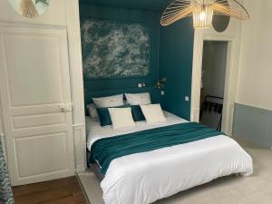 a bedroom with a large bed with blue walls at Aux Remparts de Montreuil in Montreuil-sur-Mer +26 photos