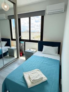 a bedroom with a blue bed and a large window at Yenikent's Diamond in Nicosia