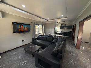 KitweにあるChidi Apartments CEC Village 24 7 Powerのソファとテレビのあるリビングルーム