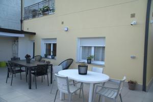 a room with two tables and chairs and windows at Apartamento El Castillo VT1 in Sarria