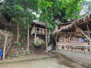 a house with a hammock in front of it at Private Beachfront Retreat in El Nido