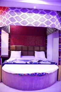 Un dormitorio con una cama grande con cabecero rojo. en D Season Hotel, en Agra