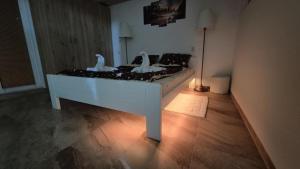 three white birds sitting on a bed in a room at Apartmani Tiski Labud in Bečej