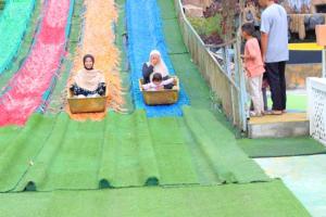 two women and a child riding on a roller coaster at villa taman surga rinjani in Sembalun Lawang