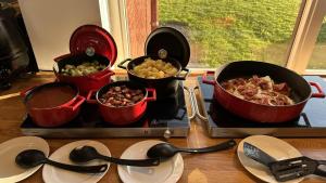 a group of pots and pans on a stove with food at Slobrua Gjestegård in Skarnes