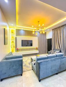 a living room with two blue couches and a tv at Executive 2 bedroom apartment in Lagos