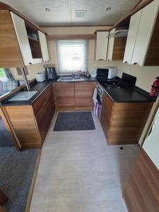 a kitchen with wooden cabinets and black counter tops at Duck Creek at Beacon Fell View in Longridge