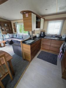 a kitchen with wooden cabinets and a living room at Duck Creek at Beacon Fell View in Longridge
