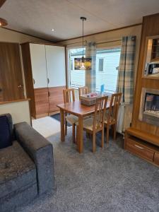 a living room with a table and chairs and a couch at Duck Creek at Beacon Fell View in Longridge