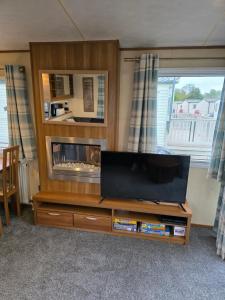 a living room with a flat screen tv on a entertainment center at Duck Creek at Beacon Fell View in Longridge +18 photos