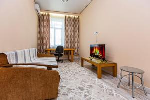 a living room with a couch and a tv at Шикарная Двушка в самом центре Алматы #12 in Almaty
