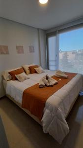 a large bed in a room with a large window at Parque Suite Nqn - 1 dormitorio in Neuquén