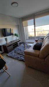 un salon avec un canapé et une télévision dans l'établissement Parque Suite Nqn - 1 dormitorio, à Neuquén 27 autres photos