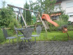 un parque infantil con sillas, una mesa y un tobogán en Ferienwohnung Jutta, en Höchst