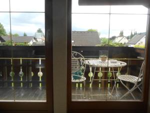 einen Balkon mit einem Tisch, 2 Stühlen und einem Fenster in der Unterkunft Ferienwohnung Jutta in Höchst