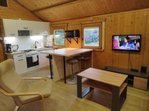a kitchen with a table and a tv in a cabin at Lavender Retreat in Krakow
