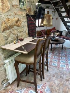 a table and chairs in a room with a stone wall at Castell de Tati in Platja  d'Aro