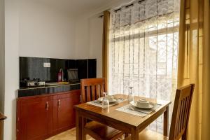 a kitchen with a wooden table and a dining room at 1BDM Aptmt Free Wifi,TV, NETFLIX,FRIDGE,KITCHEN-busy area in Dar es Salaam +20 photos