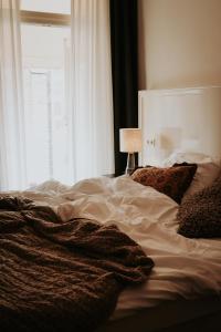 an unmade bed in a bedroom with a window at Sevenster Delden in Delden