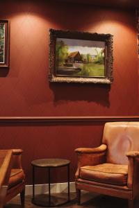 a painting on a wall with a chair and a table at Sevenster Delden in Delden +54 photos