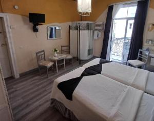 ein Hotelzimmer mit einem großen Bett und einem Fenster in der Unterkunft Hospedaje Botin in Santander + 33 Fotos