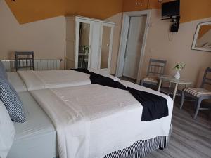 ein großes weißes Bett in einem Zimmer mit einem Tisch in der Unterkunft Hospedaje Botin in Santander