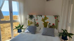 a bedroom with a bed with a cactus mural on the wall at Torre dei Pirati in Letojanni