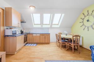 a kitchen with a table and a clock on the wall at Apartment Gaspercic in Bovec