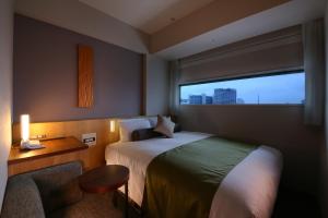 A bed or beds in a room at Hotel Gracery Shinjuku