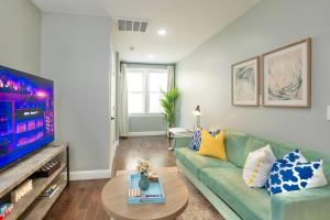 a living room with a green couch and a tv at Spacious 3BR Near NYC with Workspace in Newark