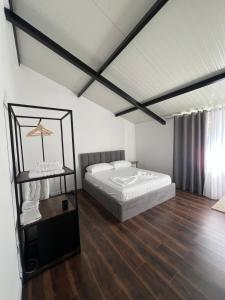 a white bedroom with a bed and a table at Te gjoli in Pogradec