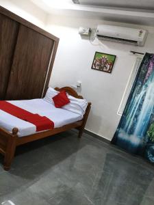 a bedroom with a bed with a red and white sheets at Garuda Grand in Tirupati