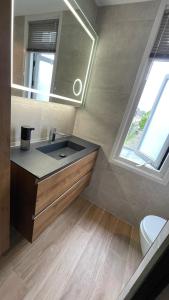 a bathroom with a sink and a mirror at A whole Family expat house with AC, garden, close to Efteling in Tilburg