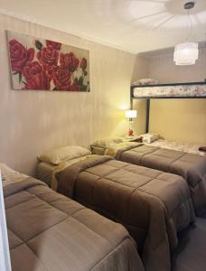 a room with three beds and a painting on the wall at Departamento Parana 2 in Posadas