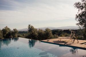 a swimming pool with a chair sitting next to it at Tepee - Glamping Maremma, Toscana in Roccastrada