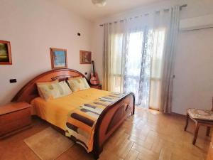 a bedroom with a large bed and a large window at Guest house near historical center in Vlorë