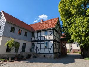 a white and black house with a red roof at Historisches Forsthaus Wachstedt in Wachstedt
