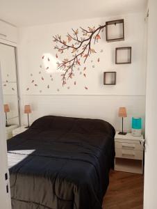 a bedroom with a bed with a branch on the wall at Aconchego house in Sao Paulo