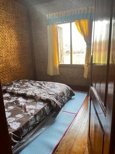 a bedroom with a bed and a window at Zann Villa Ciwidey in Panundaan