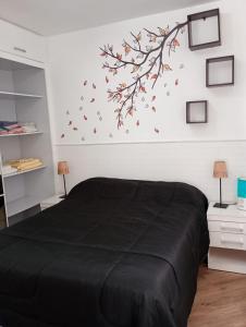 a bedroom with a black bed with leaves on the wall at Aconchego house in Sao Paulo +36 photos