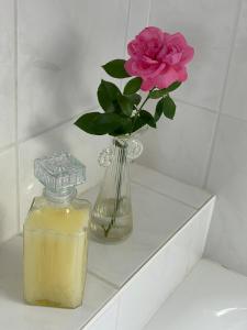 a vase with a pink rose and a candle on a shelf at Moderne Ferienwohnung in Bad Salzuflen - Zentrale Lage & Wohlfühlkomfort in Bad Salzuflen +20 photos