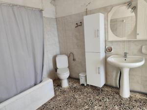 a bathroom with a toilet and a sink and a shower at Panorama Georgia's house in Áyios Vasílios +30 photos