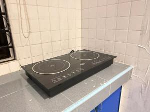 a black stove top in a tiled kitchen at White House - Alor Setar in Alor Setar