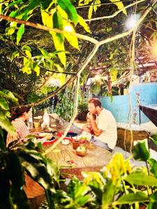 zwei Männer sitzen an einem Picknicktisch mit Essen in der Unterkunft Moksha eco villa Ella in Ella