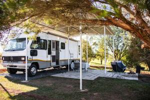 温特顿Tranquility Glamping的一辆白色卡车停在带桌子的帐篷下