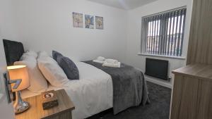 a bedroom with a bed with pillows and a television at Leyland Road Retreat - 4 Bedroom House in Burnley