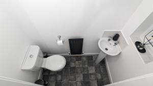 a small bathroom with a toilet and a sink at Leyland Road Retreat - 4 Bedroom House in Burnley +9 photos