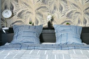 Una cama con almohadas azules y blancas y una pared en Spacieux Centre-ville Balcon, en Saint-Étienne
