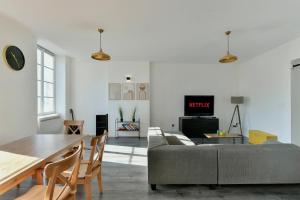 una sala de estar con un sofá y una mesa en Spacieux Centre-ville Balcon, en Saint-Étienne