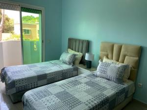 two beds in a room with blue walls at Beach palace 1 between sea pool and city center in Mohammedia +45 photos